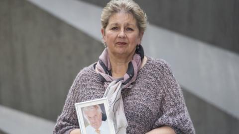 Karen Wilson holds a photograph of her late husband Julian Wilson, a former sub-postmaster, after giving evidence at the International Dispute Resolution Centre in London for the Post Office Horizon IT inquiry.