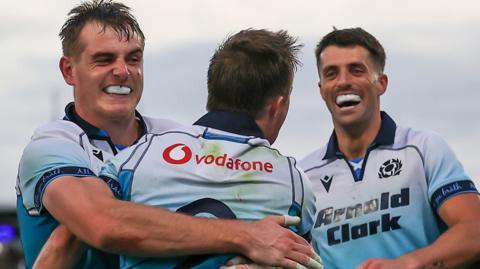 Stafford McDowell and Adam Hastings congratulate try-scorer George Horne