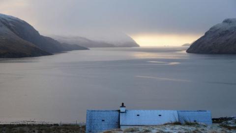 A view from North Harris. There is a light dusting of snow on a house roof and landscape beyond. Picture by Allan Macleod.