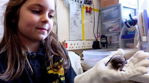 Nine-year-old Ruby holds a bat