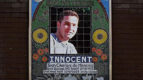 A mosaic memorial to Jean Charles de Menezes outside Stockwell Underground station in London. It reads "Innocent. Jean Charles de Menezes. Born Gonzaga MG Brazil 07-01-1978. Shot dead here 22-07-2005. Sadly missed."