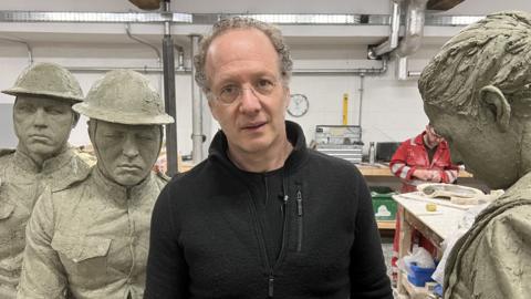 Sculptor Sabin Howard standing among his sculptures