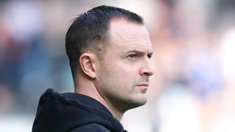 Birmingham City boss Chris Davies looking bit pensive staring ahead, headshot, wearing blue cotton hoodie down round his neck
