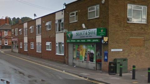 View of the Select and Save convenience store in Baggholme Road with black bin and telecoms cabinet in view