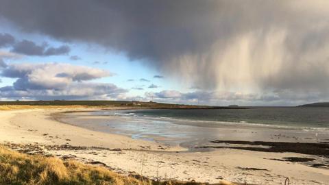 A shower cloud over the beach at Newark Bay, Orkney. Picture by 鶹ҳ Weather Watcher 'David'