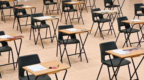 A school hall with desks arranged for exams