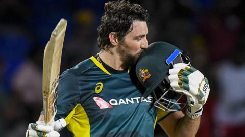 Tim David kisses the Australia badge on his helmet