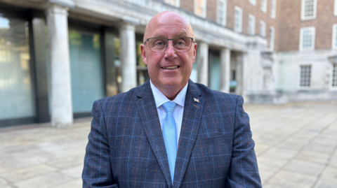 Nottinghamshire County Council leader Mick Barton is pictured wearing a blue-striped blazer, shite shirt and powder blue tie