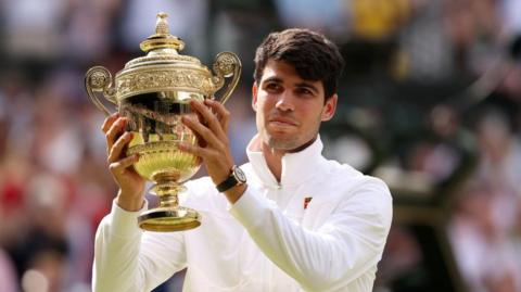 Carlos Alcaraz holds the Wimbledon men's singles trophy