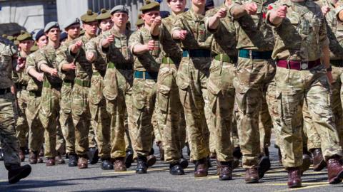Soldier marching in formation along a street