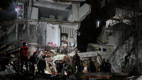 First responders work at the site of a projectile impact, as the U.S.-Israel conflict with Iran continues, in northern Israel.