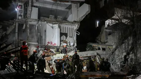 First responders work at the site of a projectile impact, as the U.S.-Israel conflict with Iran continues, in northern Israel.