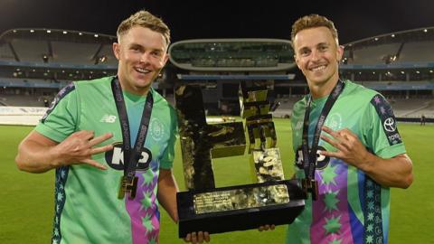 Sam Curran and Tom Curran holding the Hundred trophy