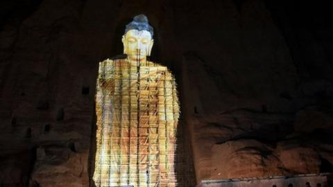 People watch a 3D projection of the 56 metre-high Salsal Buddha at the site where the Buddhas of Bamiyan statues stood before being destroyed by the Taliban in March 2001.