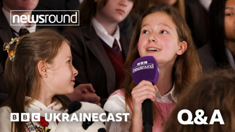 Children taking part in Ukrainecast speaking into a Newsround microphone