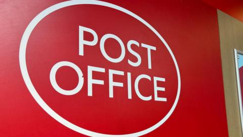 A red and white Post Office sign