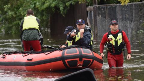 Orange County Fire rescue unit members work in a flooded neighbourhood