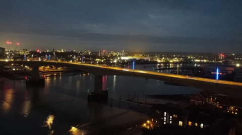 An aerial view of blue stanchions on the Itchen Bridge at night.