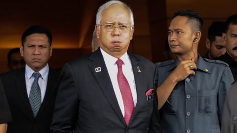 Malaysia' Prime Minister Najib Razak (C) reacts as he walks towards his car after attending a parliamentary session in Kuala Lumpur on 26 January 2016