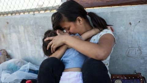 Mother hugs infant