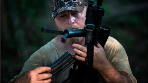 Chris Hill, founder of the Georgia Security Force III% militia, loads a rifle during a field training exercise July 29, 2017 in Jackson, Georgia