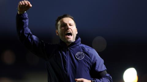 Walsall manager Mat Sadler celebrates at full-time after winning 4-2 at Newport County
