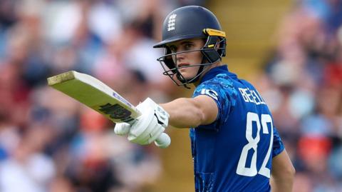 England batter Jacob Bethell raises his bat after hitting fifty