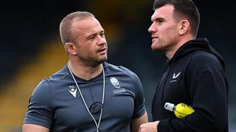 Worcester Warriors forwards coach Tom Cruse (left) talking to Ben Spencer from Bath before a pre-season friendly 