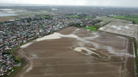 An aerial view of Bilton, with rows of houses surrounded by flooded fields