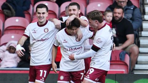 Yu Hirakowa celebrates scoring his first goal for Bristol City, surrounded by teammates