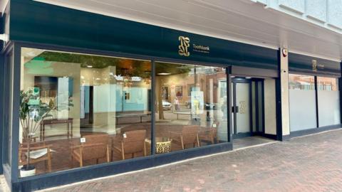 View of the exterior of the surgery, which is in a modern building on a pedestrianised square
