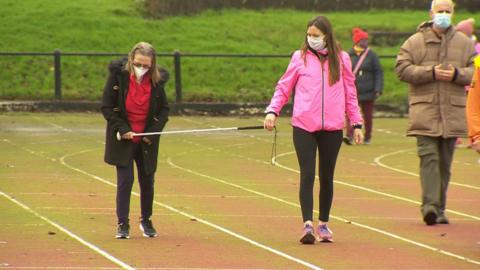 Visually impaired person exercises with assistance