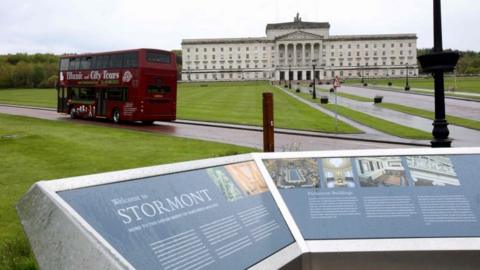 A sightseeing bus driving towards Stormont's Parliament Buildings