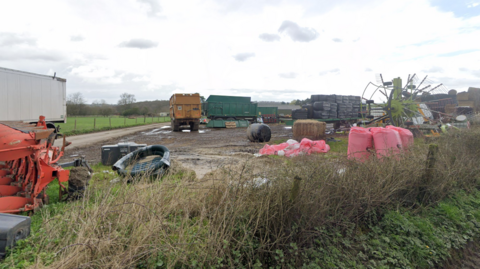 Muddy ground in the country side with farm equipment and lorry