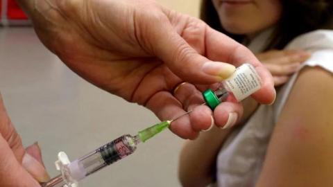 Doctors fill syringe in preparation for a vaccination