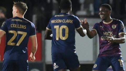 Peterborough players celebrate scoring a goal in the FA Cup first-round replay against Salford City