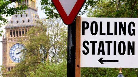 A polling station direction sign is attached to a street sign near the Elizabeth Tower, more commonly known as Big Ben, ahead of local elections, in London, Britain, May 1, 2024