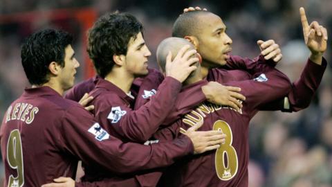 Thierry Henry celebrates with his team-mates after scoring a hat-trick