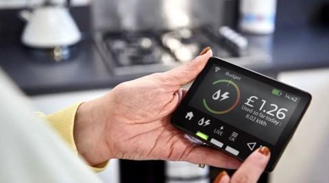 Woman with painted nails holding an electricity smart meter 