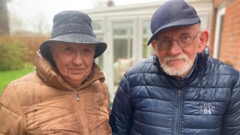 Patricia Clarke and Peter Clarke standing in the rain