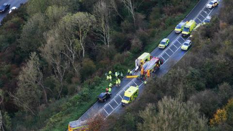 An aerial view of the scene on Mill Road with several of emergency vehicles parked on the road