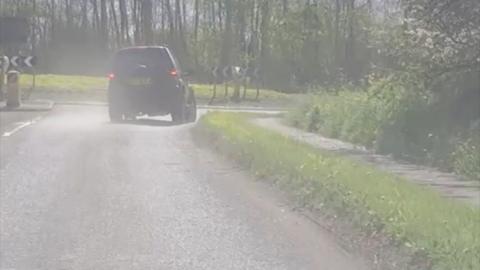 Car being drive wrong way around roundabout