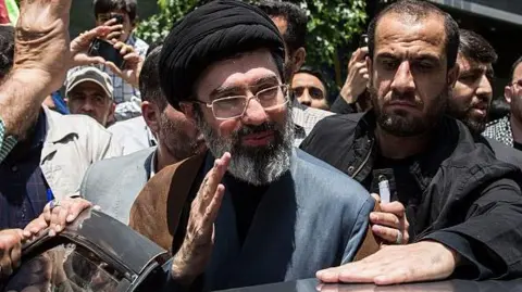Mojtaba Khamenei surrounded by people, getting into a car