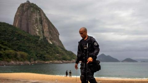 A member of the military police, patrols during a police operation in Vermelha beach at Urca neighbourhood, Rio de Janeiro, Brazil, on June 8, 2018