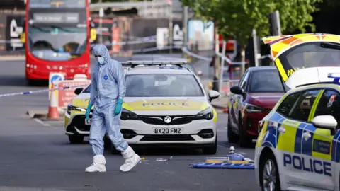 Body-worn footage showing a police officer's arm holding a Taser, another officer to the left and the knife suspect walking towards them