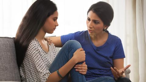 Mother and daughter have a tough conversation about GCSE results on the sofa