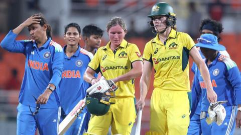 Beth Mooney and Annabel Sutherland of Australia leave the field after beating India in the first one-day international
