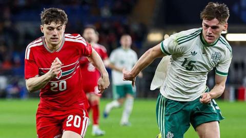 Dan James of Wales and Justin Devenny of Northern Ireland chase the ball during a friendly in Cardiff in March 2026