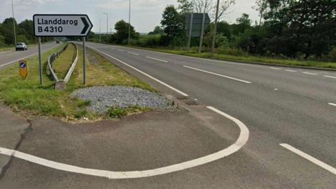 A sign on the A48 dual carriageway indicating the turn in for Llanddarog