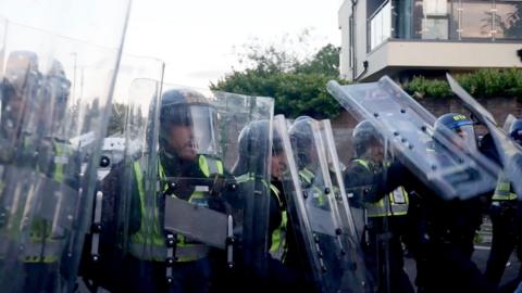 Police officers wield riot shields in a confrontation with protesters in Southampton on 2.6.26